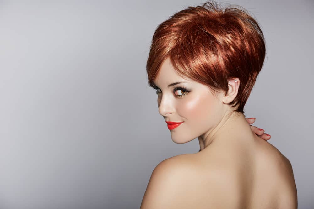 Woman with red hair in pixie style.