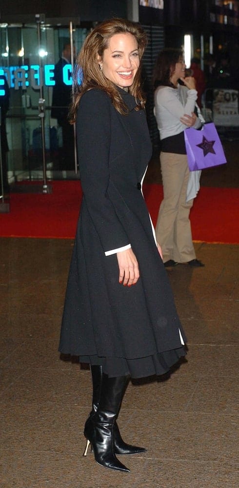 Angelina Jolie was all smiles in her lovely black dress and black boots at the UK premiere of 'Alexander' at the Odeon, Leicester Square on January 5, 2005. She paired this dress with her medium-length tousled loose hairstyle with a brown hue.