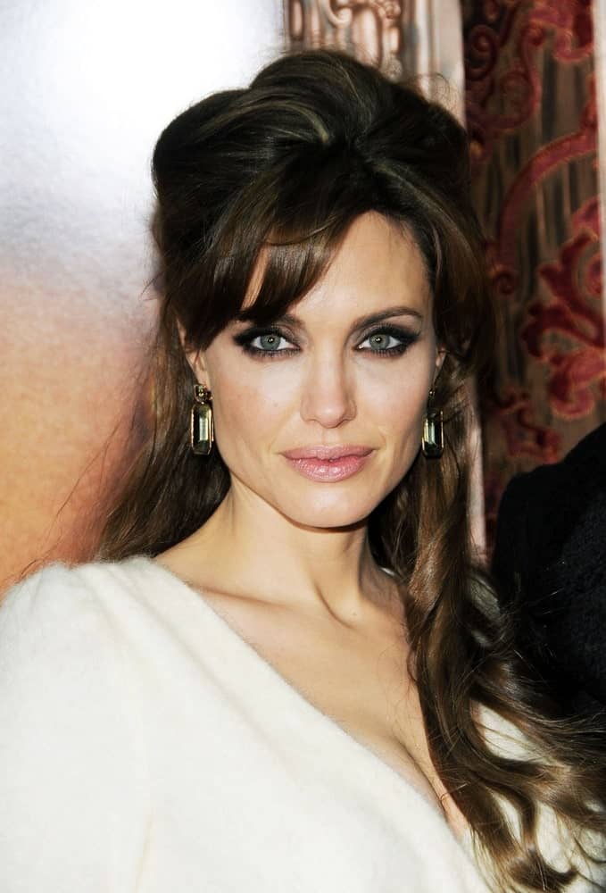 Angelina Jolie's simple make-up and white furry dress was a nice pairing for her messy half up hairstyle with highlights and waves at the tips at THE TOURIST Premiere in The Ziegfeld Theatre, New York on December 6, 2010.