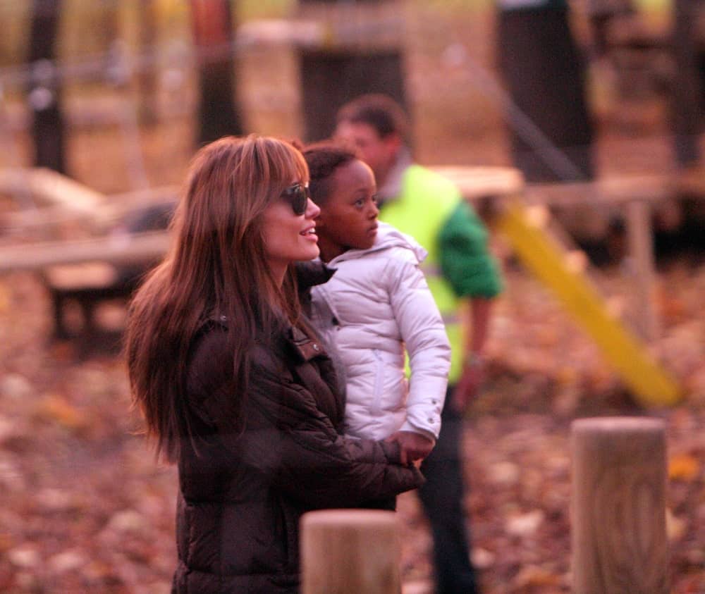 On November 5, 2010, Angelina Jolie was out and about when she took her children to a park in Budapest. She was wearing a large black winter jacket with her long and tousled loose hair with layers and bangs.