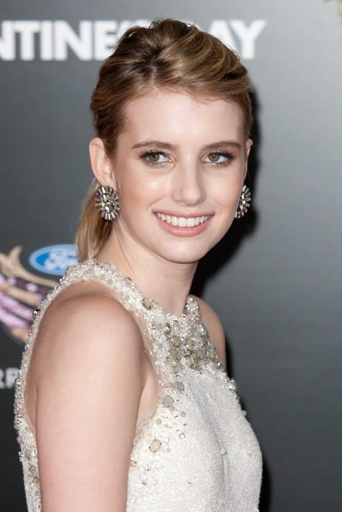 Emma Roberts was at the premiere of Valentine's Day at Grauman's Chinese Theater on February 8th 2010 in Hollywood. She wore a bejeweled beige dress with her low bun brunette hairstyle.