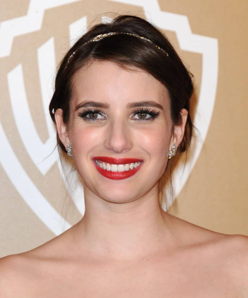 Emma Roberts was at the WB/In Style Golden Globe Party on January 13, 2013 in Hollywood, CA. She wore a strapless dress with her messy dark bun hairstyle with a golden headband.