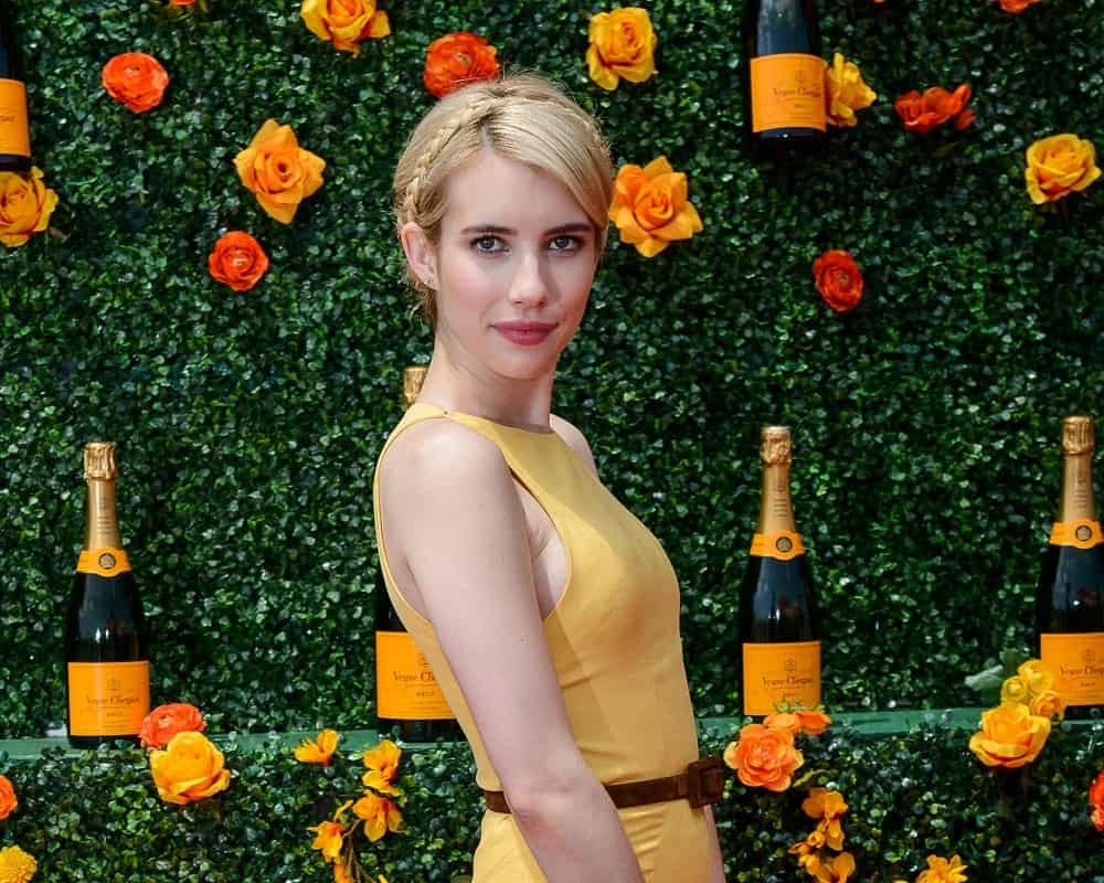 On May 30, 2015, Emma Roberts attended the 8th Annual Veuve Clicquot Polo Classic in Liberty State Park, New Jersey City. She paired her charming yellow dress with a blonde bun hairstyle incorporated with braids.