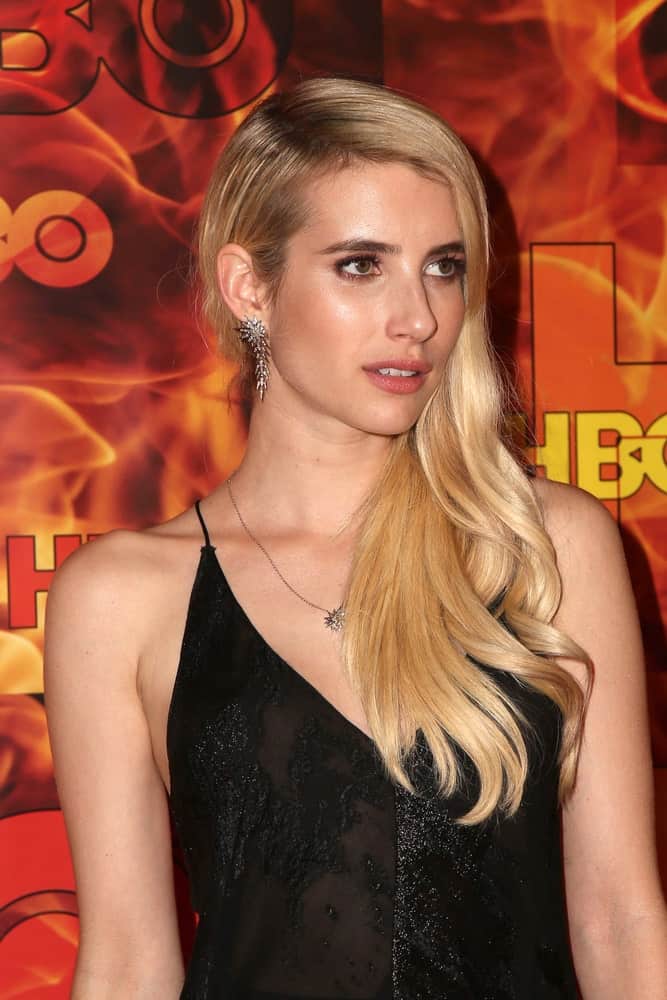 Emma Roberts was at the HBO Primetime Emmy Awards After-Party at the Pacific Design Center on September 20, 2015 in West Hollywood, CA. SHe wore a stunning black dress with her side-swept long and wavy blonde hairstyle with layers.