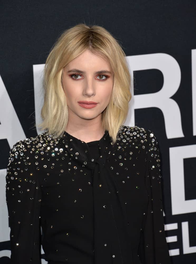 On February 10, 2016, actress Emma Roberts was at the Saint Laurent at the Palladium fashion show at the Hollywood Palladium. She wore a sparkly black dress with her shoulder-length tousled blonde bob hairstyle with layers.