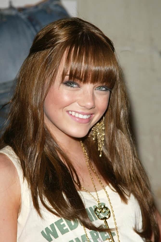 A young Emma Stone attended the Brandon Davis and Replay celebrate store opening and the launch of The Brandon Davis Jean at Falcon on April 24, 2006 in Los Angeles, CA. She wore casual clothes to pair with her tousled and straight half-up hairstyle with blunt bangs.