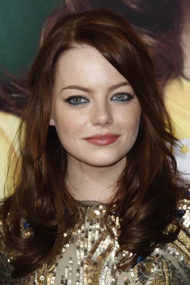 Emma Stone attended the premiere of 'Easy A' at the Grauman's Chinese Theater in Los Angeles, California on September 13, 2010. She wore a lovely gold sequined dress to pair with her layered dark red hair that has tight curls at the tips.
