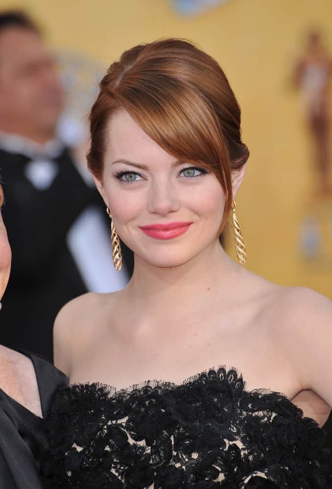 Emma Stone's gorgeous red hair was swept up into a neat bun hairstyle with long side-swept bangs at the 17th Annual Screen Actors Guild Awards at the Shrine Auditorium, Los Angeles on January 29, 2012 in Los Angeles, CA.