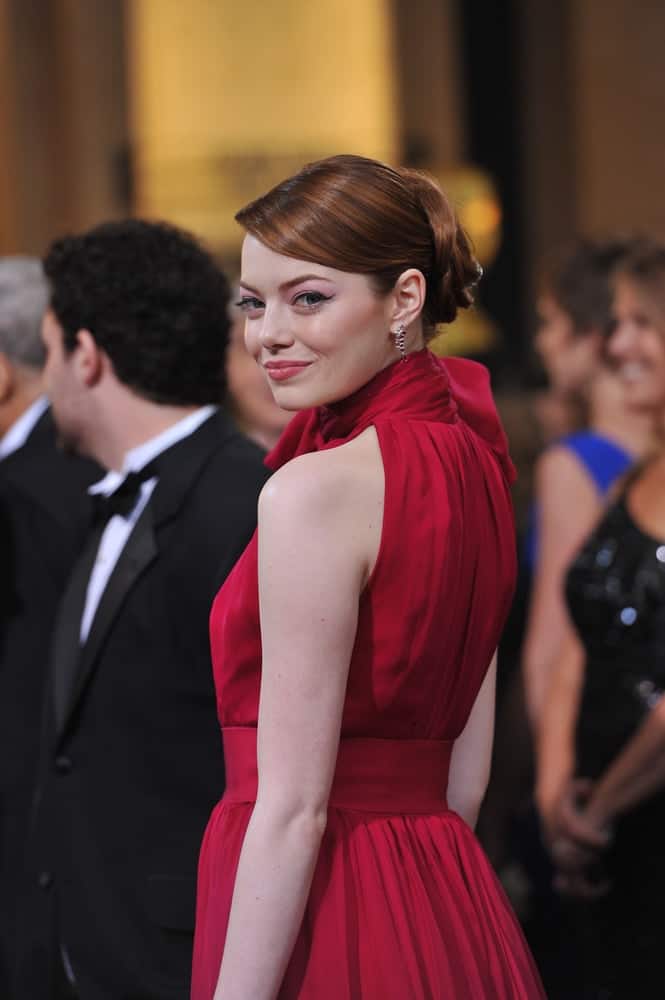 Emma Stone's highlighted red hair was styled into this elegant upstyle with side-swept bangs to match her lovely red dress at the 84th Annual Academy Awards at the Hollywood & Highland Theatre, Hollywood on February 26, 2012 in Los Angeles, CA.