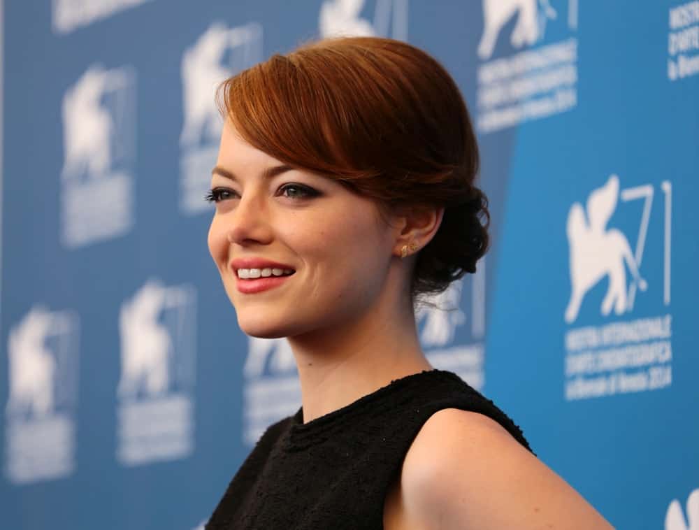 On August 27, 2014, Emma Stone was at the photocal of the film " Birdman " during the 71th Venice Film Festival 2014 in Venice, Italy. She paired her simple black outfit with an elegant and stylish low bun hairstyle with side-swept bangs.