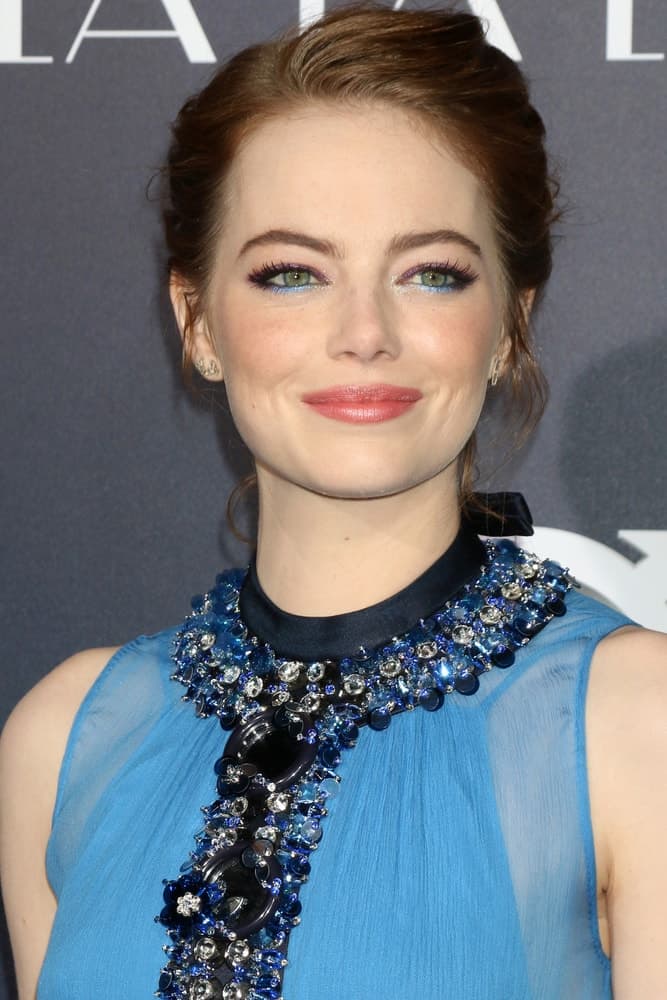 Emma Stone was at the "La LA Land" World Premiere at Village Theater on December 6, 2016 in Westwood, CA. She paired her elegant messy bun hairstyle with a gorgeous blue sheer dress with details