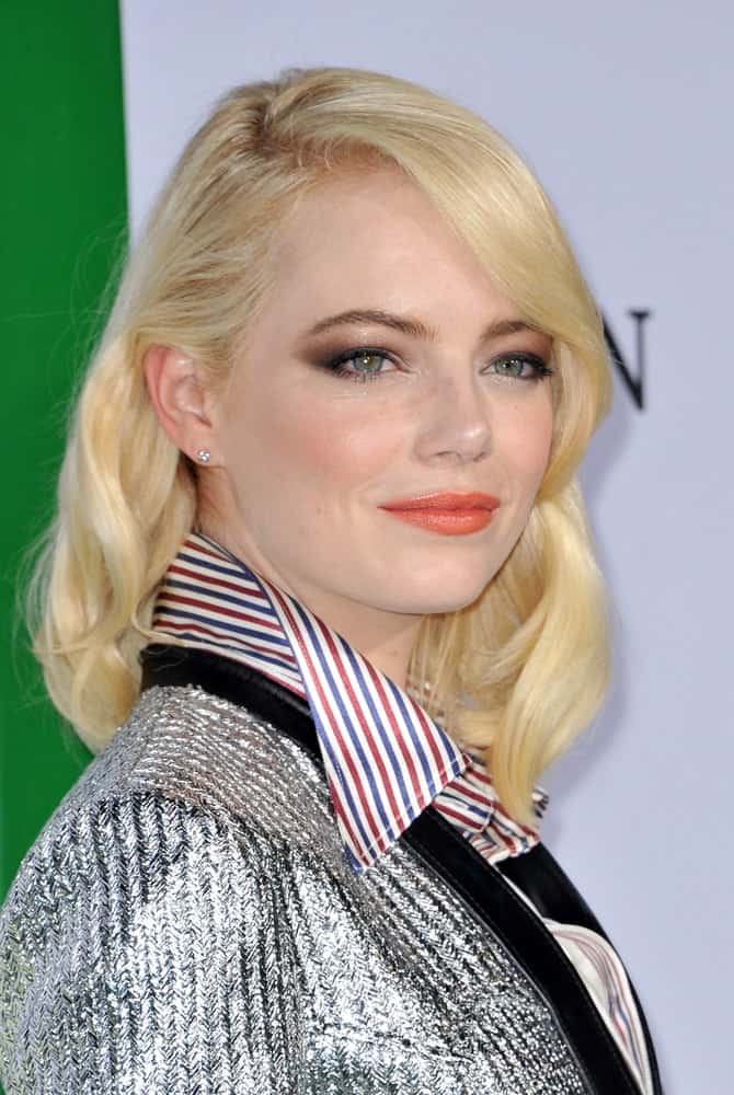 A very blond Emma Stone attended the Los Angeles premiere of 'Battle of the Sexes' held at the Regency Village Theatre in Westwood on September 16, 2017. She wore a silver outfit to go with her shoulder-length wavy layers.