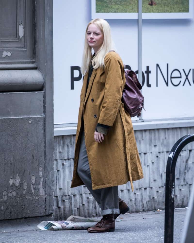Emma Stone was seen filming 'Maniac' on May 10, 2018 in the streets of New York City. She was walking in casual clothes with a large trench coat, simple make-up and silver blond long straight hair.