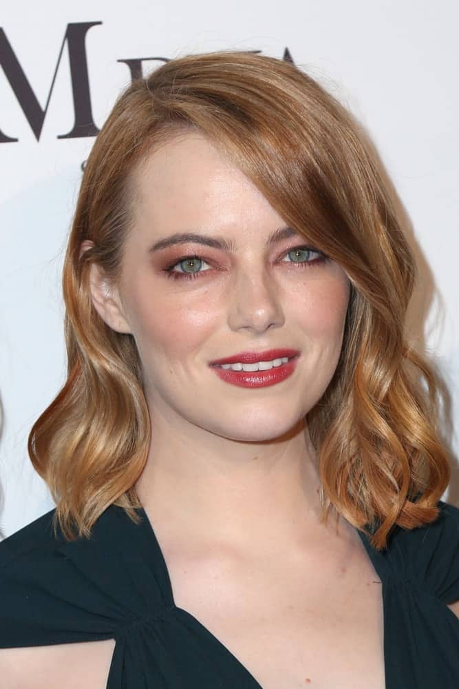 Emma Stone showcased her beautiful face and lovely smile with her gorgeous make-up and short red hair with side-swept long bangs and waves at the Marie Claire Image Makers Awards 2018 at the Delilah on January 11, 2018 in West Hollywood, CA.