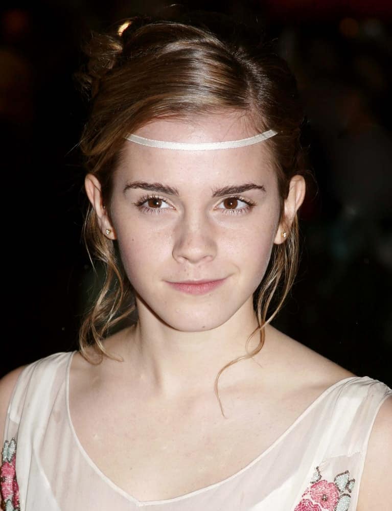 The young actress Emma Watson attended the red carpet premiere of Harry Potter on December 6, 2005 in London, England. She was wearing a floral sheer dress that pairs quite well with her messy bun hairstyle with loose tendrils.
