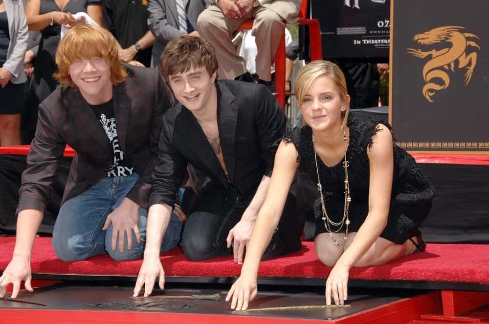 Rupert Grint, Daniel Radcliffe and Emma Watson were at the induction ceremony for Harry Potter Foot-Print and Wand-Print Ceremony in Grauman's Chinese Theatre, Los Angeles on July 09, 2007. Watson had her sandy blond hair in a bun hairstyle with tendrils and side-swept bangs.