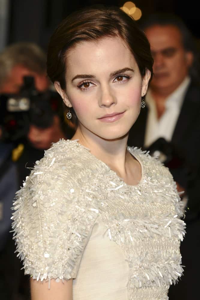 Emma Watson wore a stylish and simple white frilly dress with her elegant side-swept bun hairstyle with a slick finish at the "My Week with Marilyn" premiere at the Cineworld Haymarket in London On November 20, 2011.