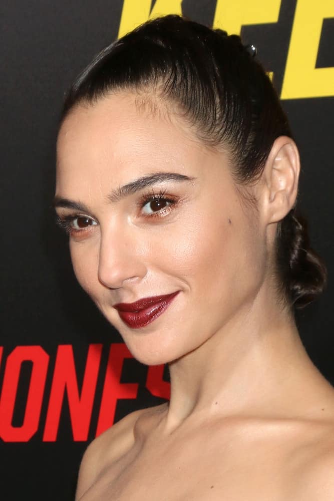 Gal Gadot was at the "Keeping Up with the Joneses" Red Carpet Event at the Twentieth Century Fox on October 8, 2016 in Los Angeles, CA. She paired her dark red lips with a slick raven bun hairstyle.