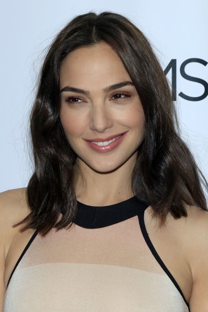 Gal Gadot was at the The Moms Present a Screening of 'Keeping Up With the Joneses' at London Hotel on October 20, 2016 in West Hollywood, CA. She came in a simple beige dress that she paired with simple makeup and shoulder-length loose tousled hair with subtle layers.