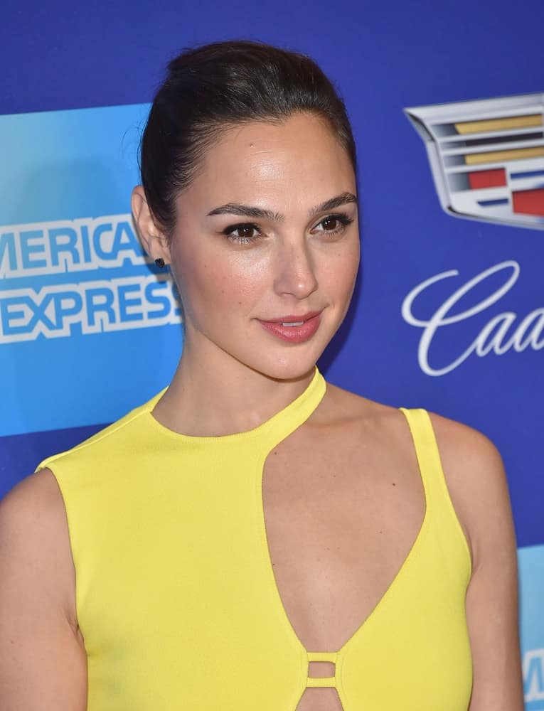 Gal Gadot was at the 2018 Palm Springs International Film Festival Awards Gala on January 2, 2018 in Palm Springs, CA. She wore an elegant bright yellow gown with her slick bun hairstyle and simple makeup.