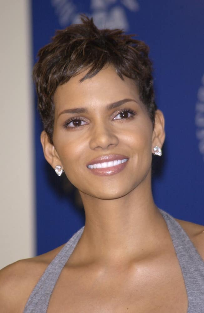 On March 9, 2002, Actress Halle Berry was at the 54th Annual Directors Guild Awards in Beverly Hills. She came wearing a simple gray outfit to pair with her tousled pixie hairstyle with subtle highlights.