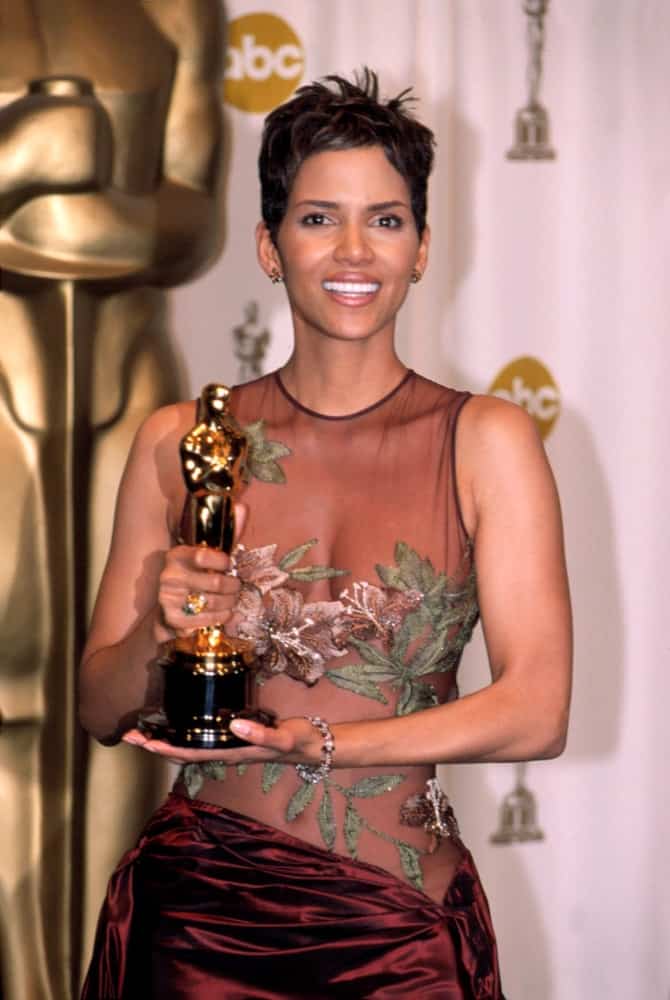 Halle Berry was brimming with pride as she held her Oscar trophy at the Academy Awards in Los Angeles, CA on March 24, 2002. She wore a stylish and sexy sheer dress with her highlighted and spiked pixie hairstyle.