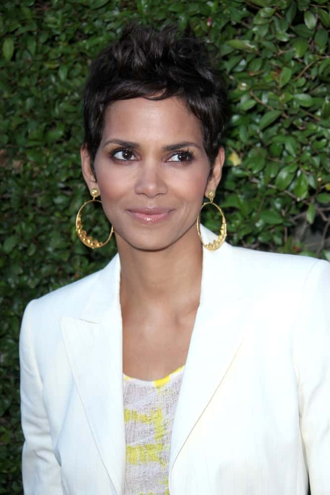 Halle Berry paired her bright white smart casual outfit with golden hoop earrings and a tousled spiked pixie hairstyle at the Opening Night of the Beauty Culture Exhibit at The Annenberg Space For Photography on May 19, 2011 in Century City, CA.