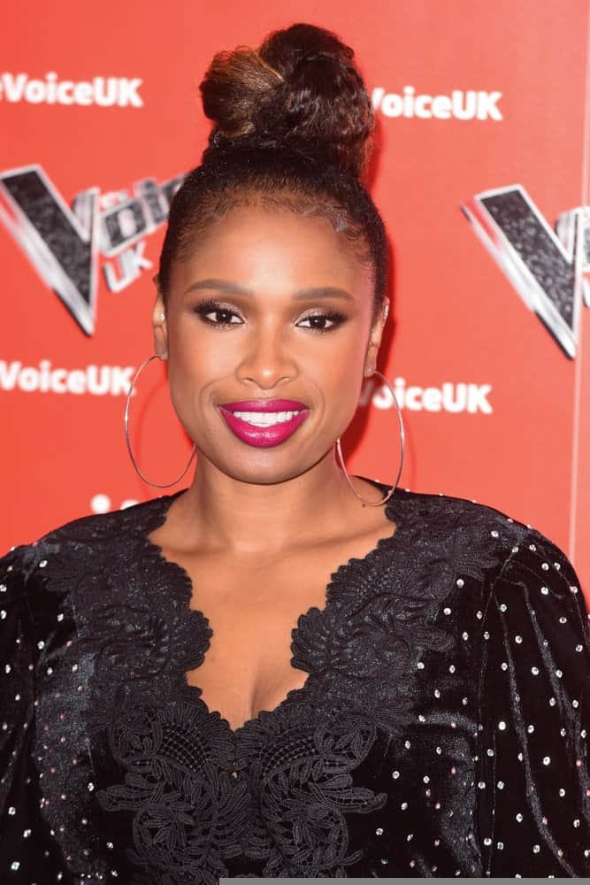 On January 03, 2019, Jennifer Hudson attended the launch photocall for the 2019 series of "The Voice" in London, UK. SHe was seen wearing a black dress with her top knot bun hairstyle with subtle highlights.