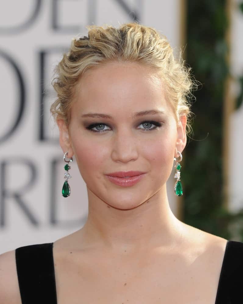 Jennifer Lawrence flaunted her beautiful earrings with a messy and highlighted bun hairstyle with loose tendrils when she arrived at the 68th Annual Golden Globe Awards on January 16, 2011 in Beverly Hills, CA.