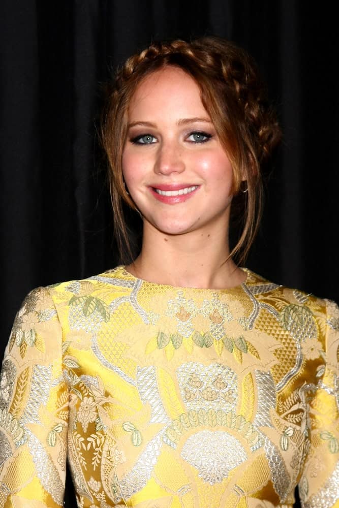 Jennifer Lawrence wore a patterned and detailed yellow outfit with her crown braid hairstyle incorporated with loose tendrils when she arrived at the 2013 LA Film Critics Awards at InterContinental Hotel on January 12, 2013 in Century City, CA.
