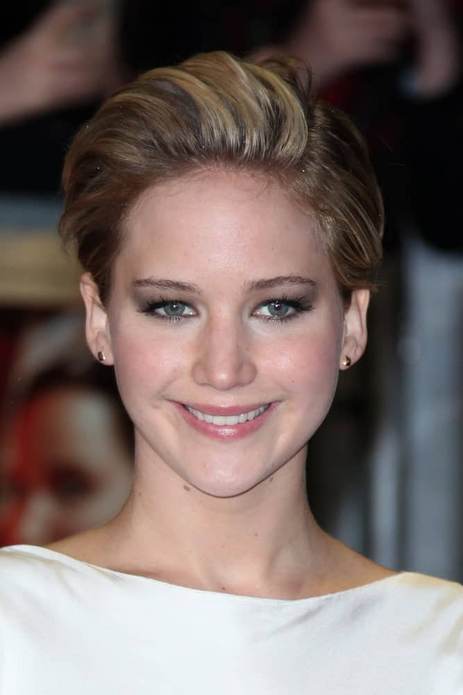 Jennifer Lawrence attended 'The Hunger Games : Catching Fire world premiere' held at Odeon Leceister Square in London on November 11, 2013. She paired her simple white outfit with a lovely side-swept highlighted pixie hairstyle.