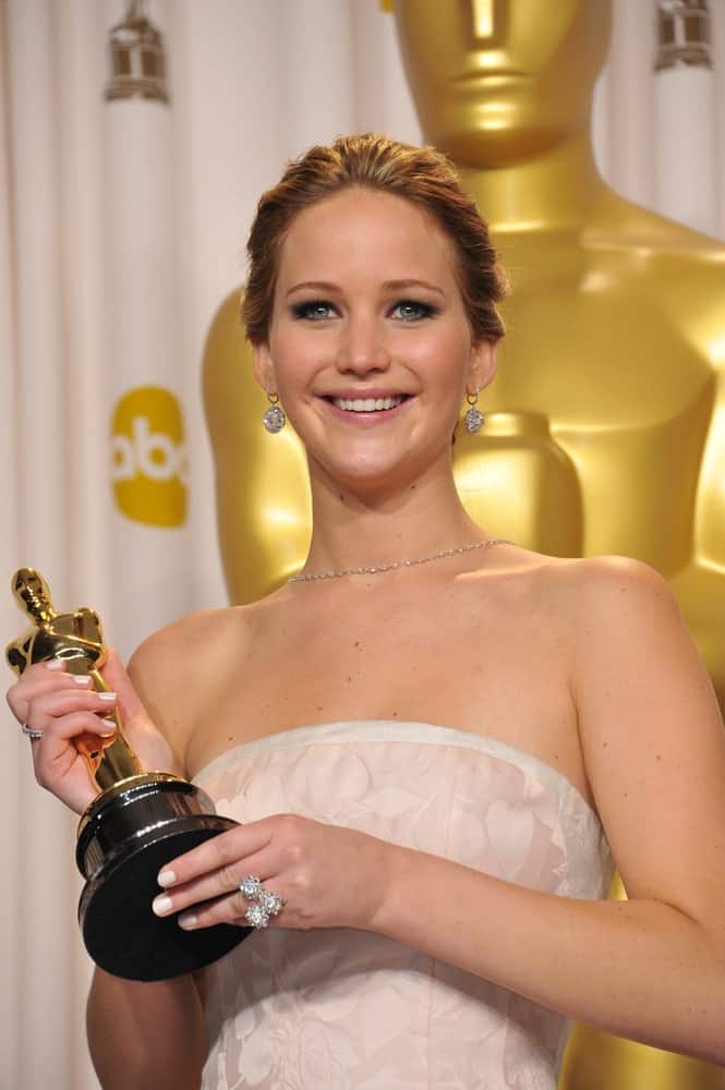 Jennifer Lawrence paired her elegant white dress with a bright smile and slicked back bun hairstyle at the 85th Academy Awards at the Dolby Theatre, Los Angeles on February 24, 2013 Los Angeles, CA.
