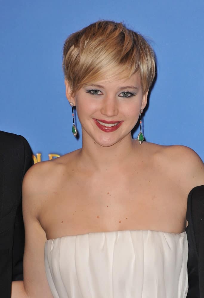 On January 12, 2014, Jennifer Lawrence highlighted her neckline and lovely earrings with a strapless white dress and a blond pixie hairstyle with long side-swept bangs in the press room at the 71st Annual Golden Globe Awards.