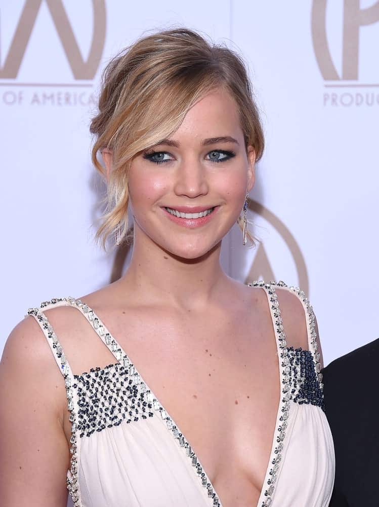 Jennifer Lawrence flashed her lovely smile when she arrived at the 26th Annual Producers Guild Awards on January 24, 2015 in Century City, CA. She wore a sexy white dress that paired well with her messy upstyle incorporated with wavy side-swept bangs.