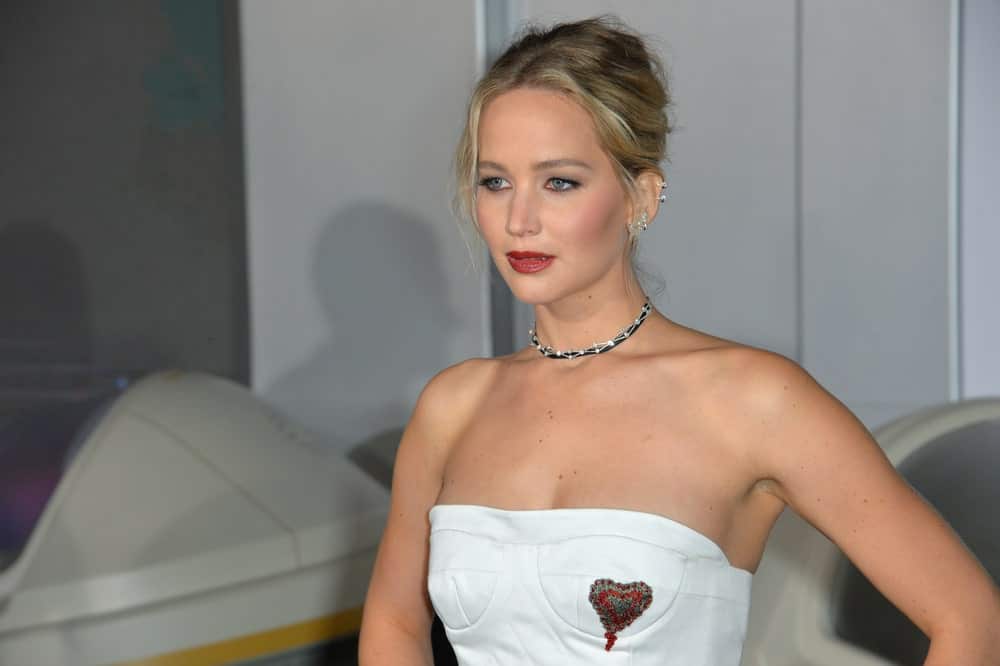On December 14, 2016, Actress Jennifer Lawrence was at the world premiere of "Passengers" at the Regency Village Theatre, Westwood. She came in a lovely white strapless dress that went well with her highlighted messy upstyle with loose tendrils.