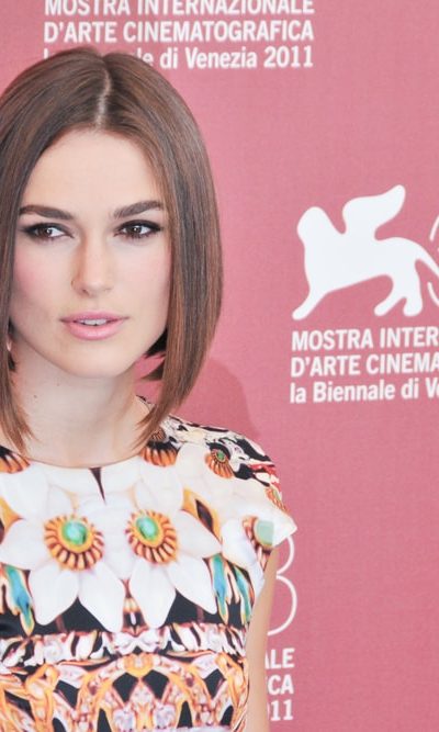 Keira Knightley poses at the photocall during the 68th Venice Film Festival at Palazzo del Cinema on September 2, 2011 in Venice, Italy. She wore a colorful floral dress with her straight bob hairstyle with a brown tone.