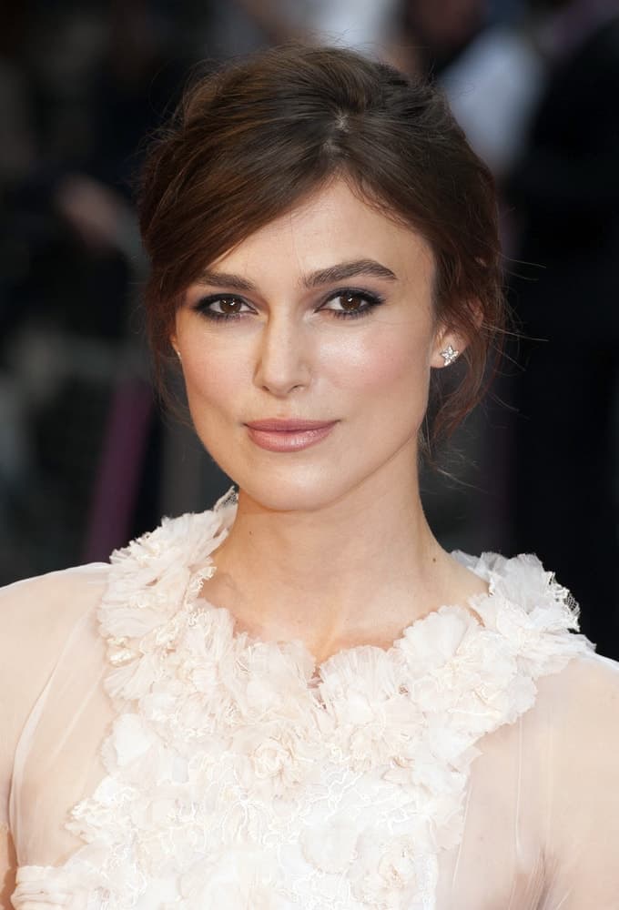 Keira Knightley attended the UK premiere of Anna Karenina at Odeon Leicester Square, London on May 9, 2012. She wore a lovely white dress with her messy side-swept bun hairstyle and simple makeup.
