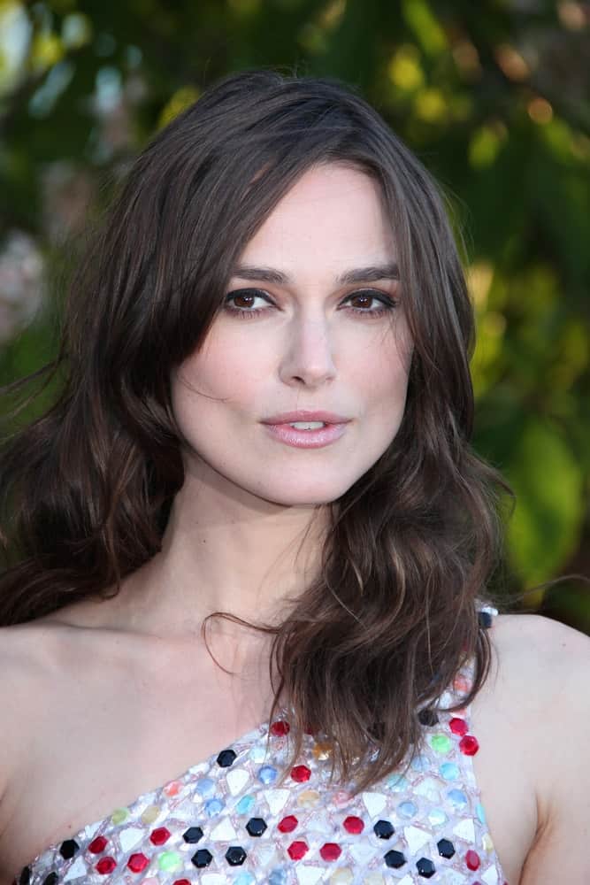 Keira Knightley attended the annual Serpentine Galley Summer Party at The Serpentine Gallery on July 1, 2014, in London, England. She came in a colorful dress to pair with her shoulder-length wavy, tousled and layered hairstyle.
