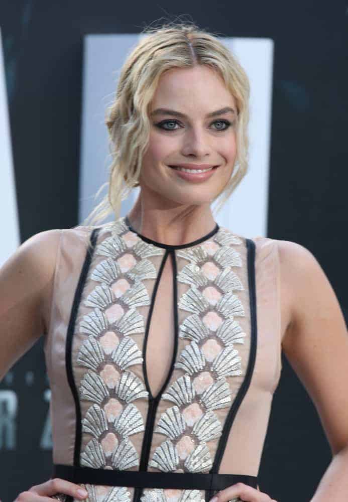 Margot Robbie with her blonde wavy upstyle hair at the European premiere of The Legend Of Tarzan on July 5, 2016. She is wearing a sheer long dress that's very classy and elegant.