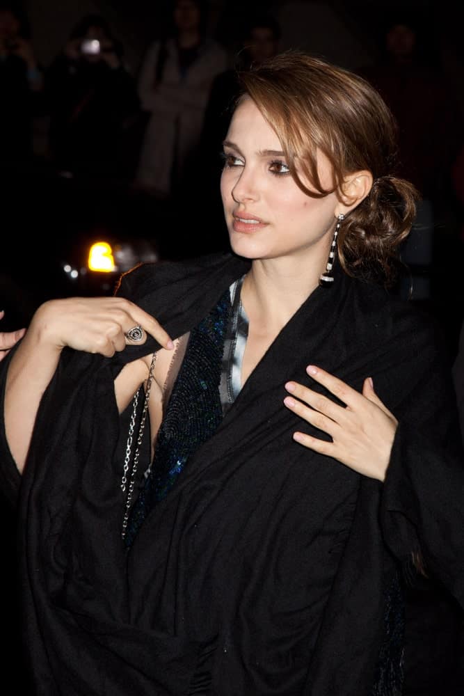 On November 30, 2009, actress Natalie Portman attended the IFP's 19th Annual Gotham Independent Film Awards at Cipriani, Wall Street. She wore a large black coat to match her messy low bun hairstyle with loose tendrils and side-swept bangs.