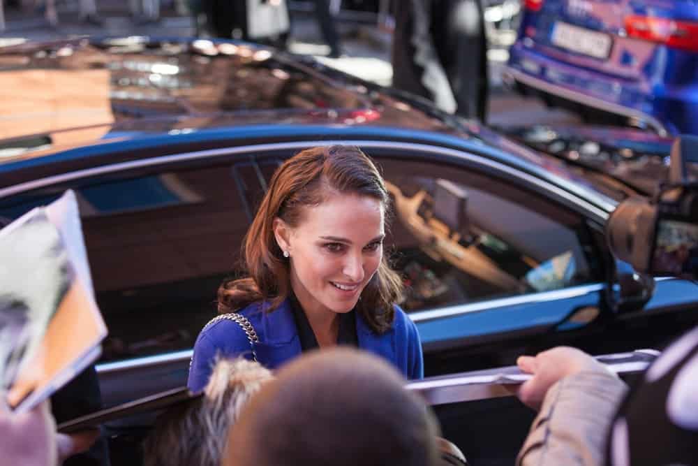Natalie Portman signed autographs at the press conference of the film "Knight of Cups" during 65 Berlinale Film Festival on February 8, 2015. She wore a blue coat that went well with her loose and side-swept wavy brunette hairstyle.