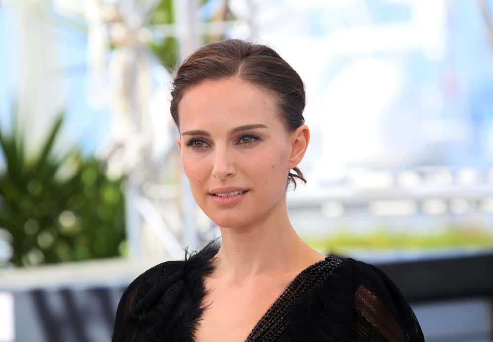 Natalie Portman went with a simple look to her dark upstyle bun hair that matched perfectly well with her sheer black dress at the 'A Tale Of Love And Darkness' photocall during the 68th annual Cannes Film Festival on May 17, 2015 in Cannes, France.