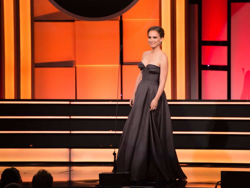 On November 10, 2017, Natalie Portman was at the American Cinematheque 2017 Award Show at the Beverly Hilton Hotel. She wore an elegant charcoal strapless dress to match her neat upstyle bun.
