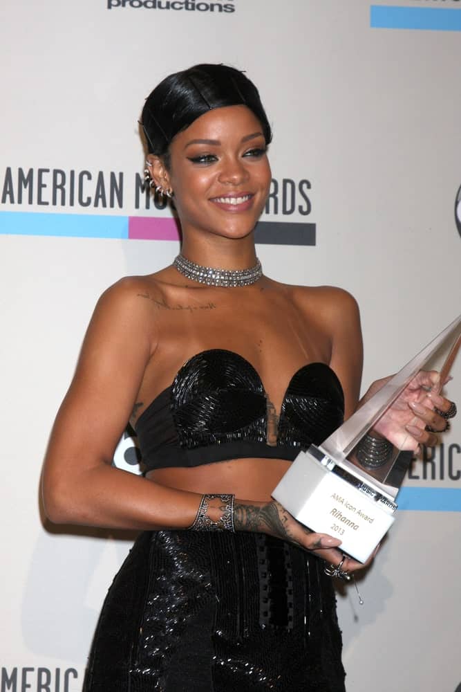 Rihanna was at the 2013 American Music Awards Press Room at Nokia Theater on November 24, 2013 in Los Angeles, CA. She wore an elegant shiny black dress that she topped with a raven slick upstyle.