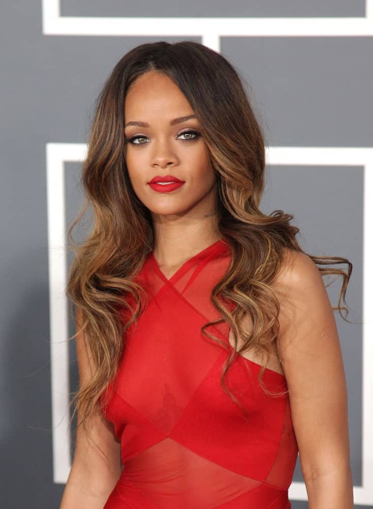 Rihanna stunned everyone with her sheer red dress that she paired with her long and wavy highlighted hair resting on her shoulders when she attended the Grammy Awards 2013 on February 10, 2013 in Los Angeles, CA.