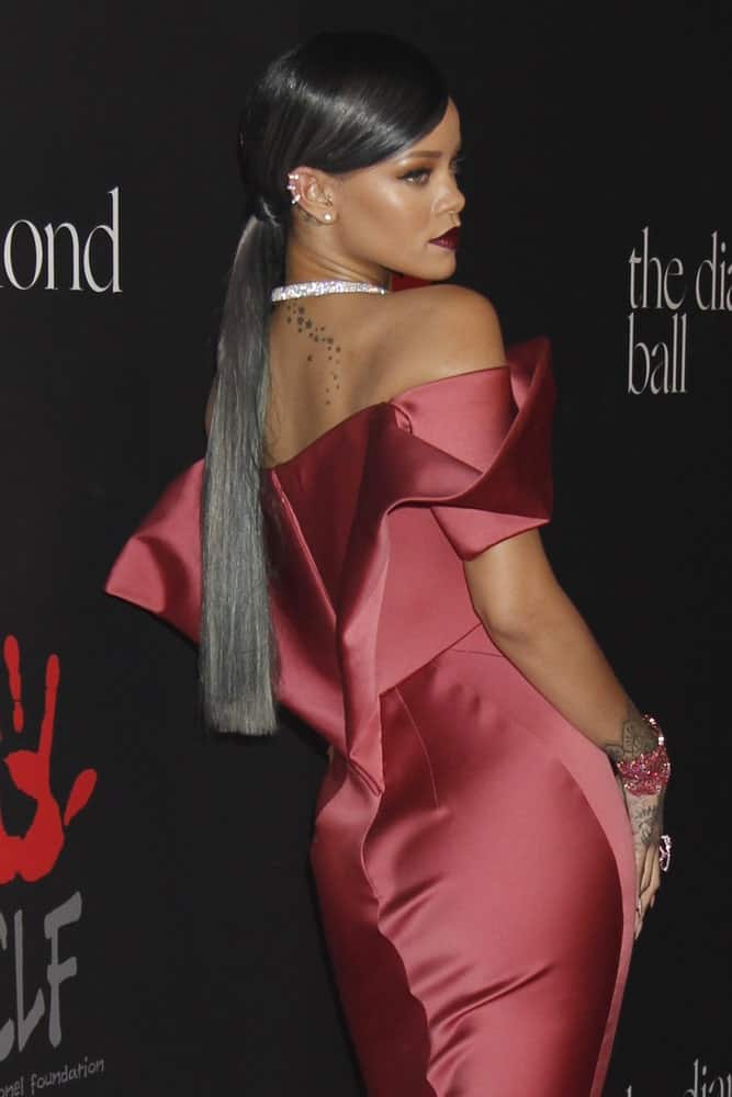 Rihanna was at the First Annual Diamond Ball at the The Vineyard on December 11, 2014 in Beverly Hills, CA. She wore a sexy form-hugging silk dress that paired well with her long straight hair with metallic highlights styled into a low ponytail.