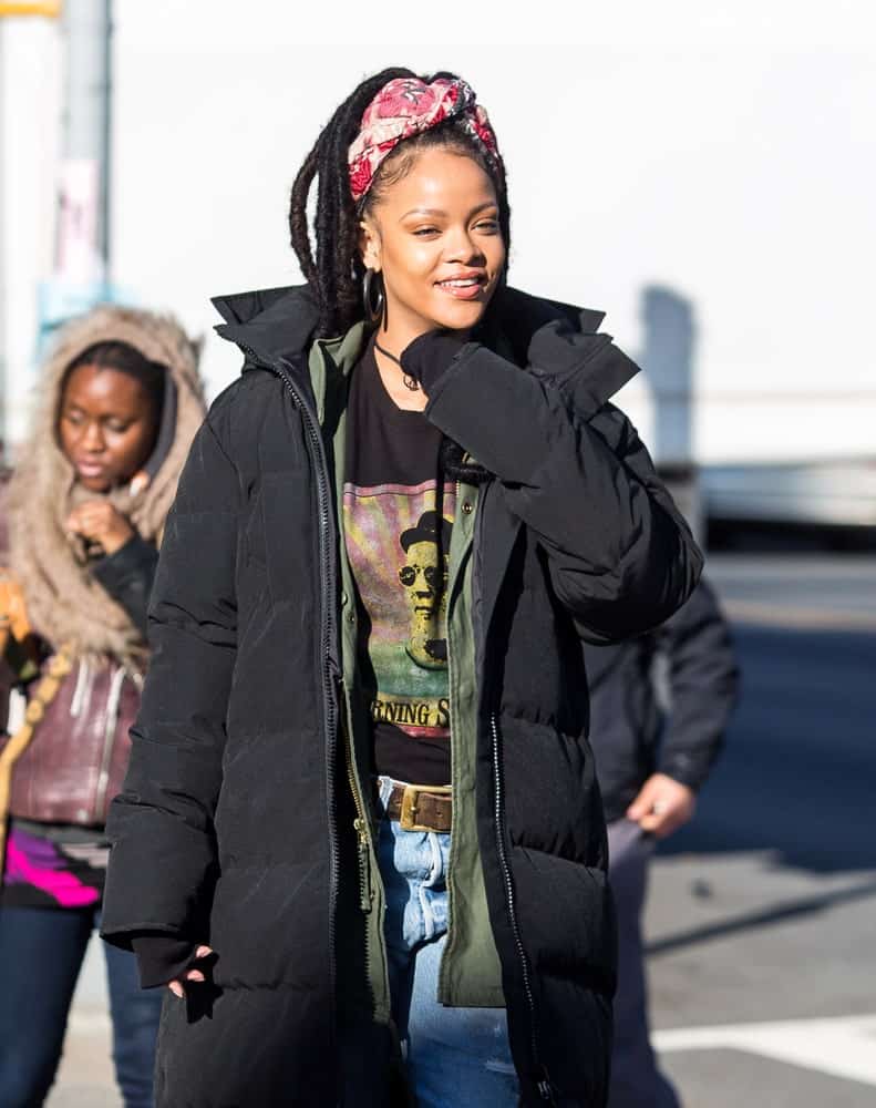 Rihanna was seen on December 5, 2016 walking the streets of New York City. She was wearing a large black winter jacket over her casual clothes and her hair was styled into long dreadlocks held up by a colorful headband.