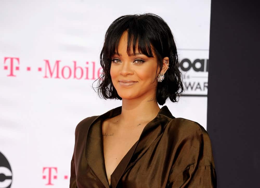 Rihanna was at the 2016 Billboard Music Awards held at T-Mobile Arena in Las Vegas, USA on May 22, 2016. Her simple dark brown outfit is complemented by her simple make-up and wavy tousled short hair with eye-skimmer bangs.