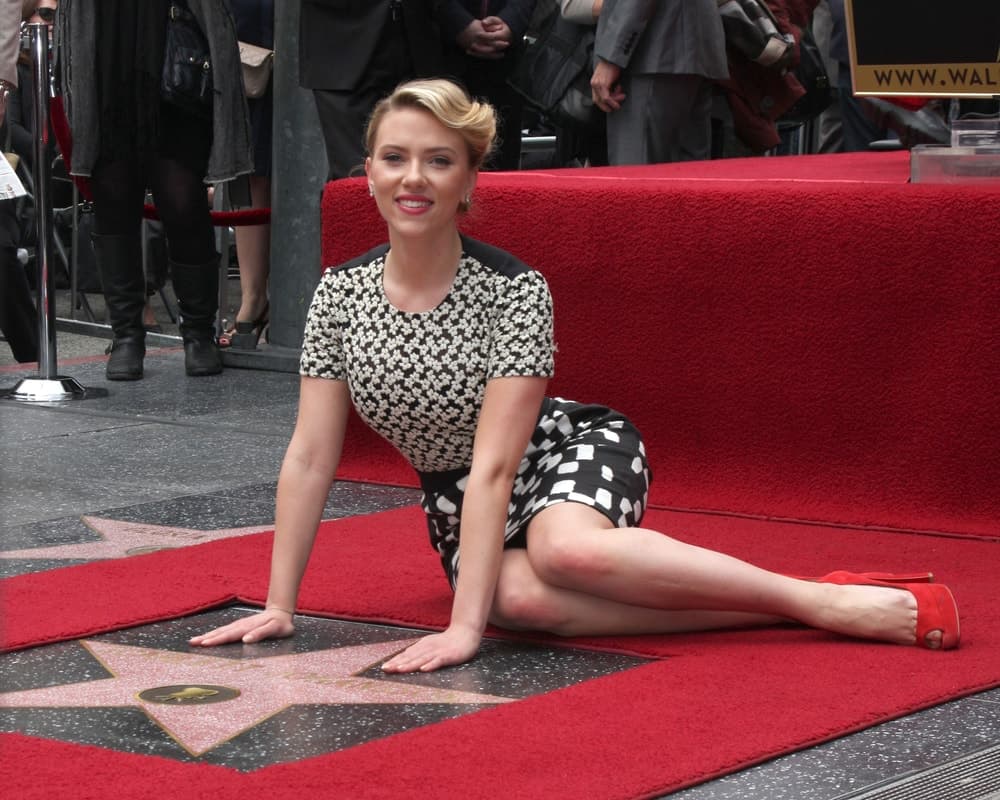 Scarlett Johansson posed with her star wearing a black and white short dress as well as an elegant upstyle with a side-swept finish at her own Walk of Fame Ceremony at Hollywood Boulevard on May 2, 2012 in Los Angeles, CA.