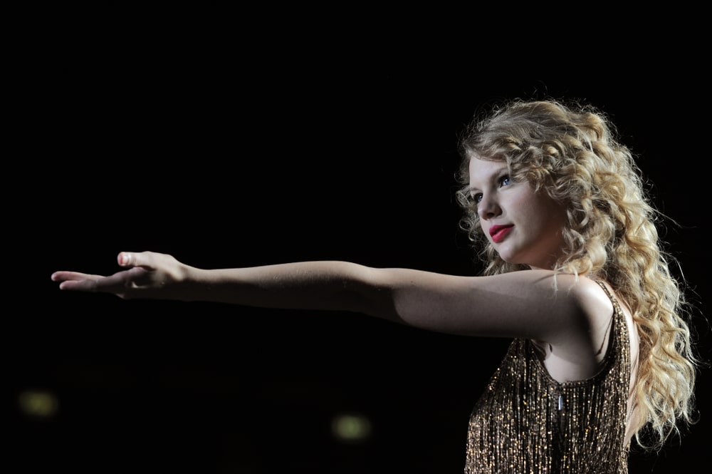Taylor Swift during her live concert at Forum Assago on March 15, 2011 rocking a long curly hairstyle paired with a sparkling dress.